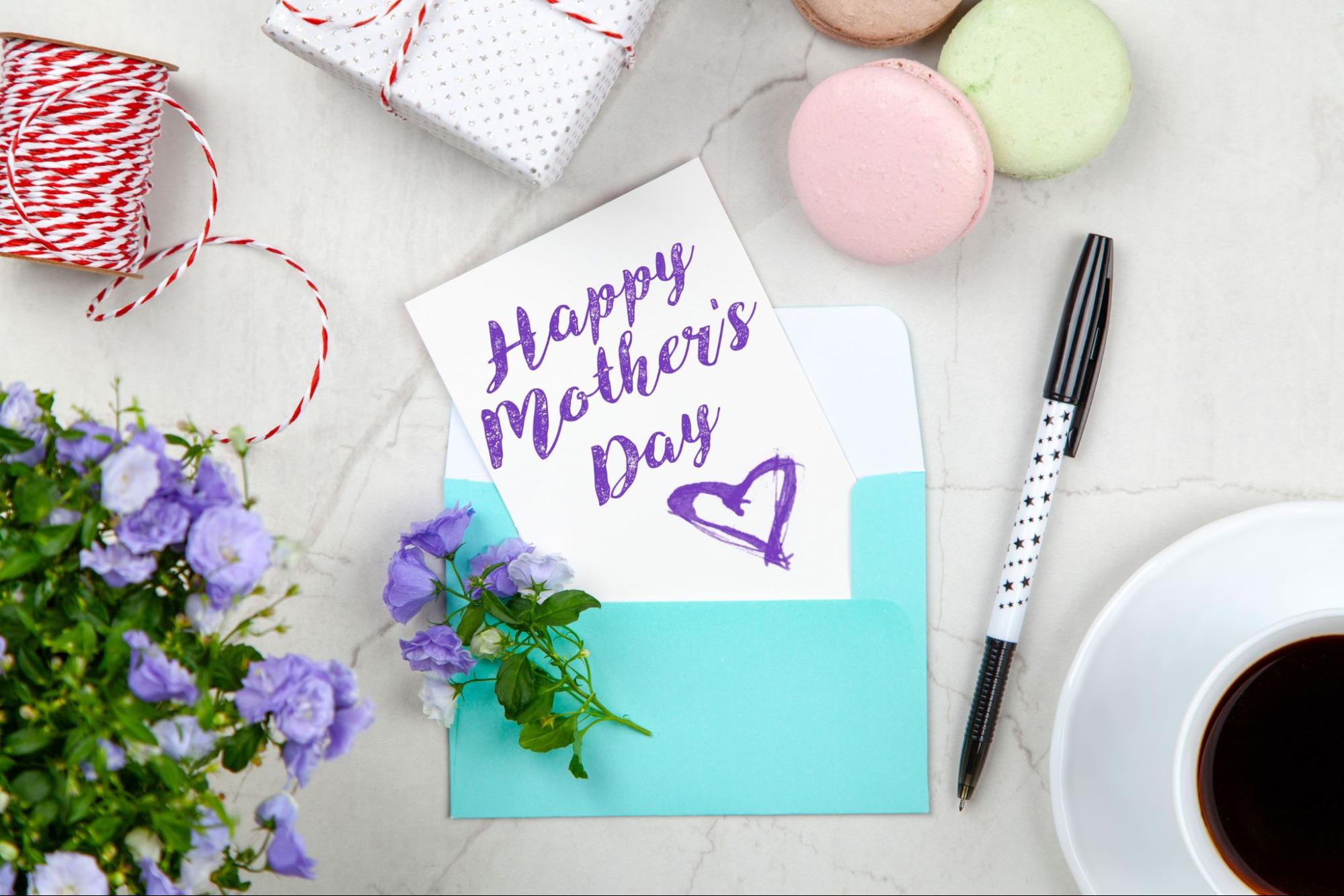 a Mother’s Day card on a table next to flowers and other items