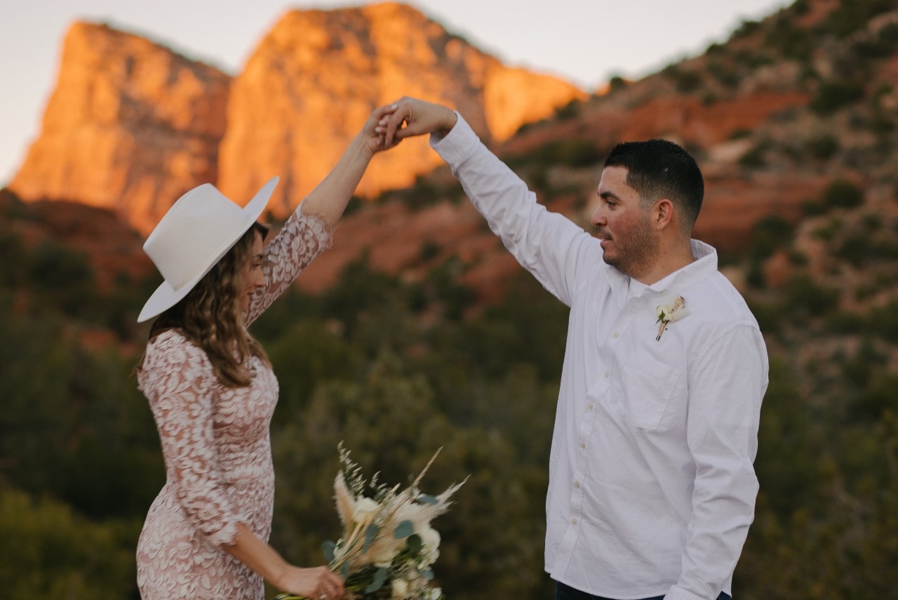Bride and groom dancing in front of a mountain range