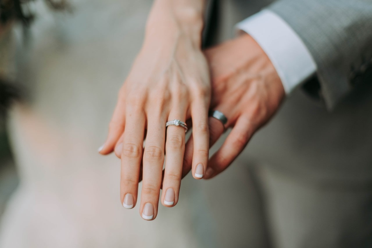 Bride and groom’s hands and wedding rings at their wedding