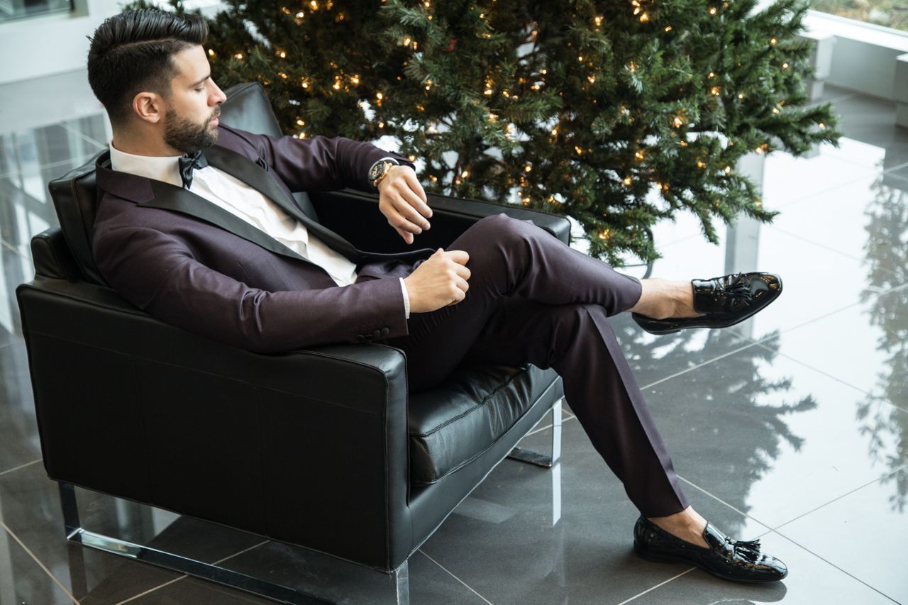 A man in a business suit checks his watch in a hotel lobby