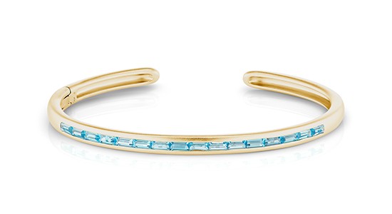 Yellow gold cuff bracelet set with blue topaz gems