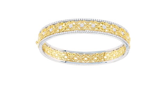 A mixed metal bangle bracelet with intricate floral details and diamond accents