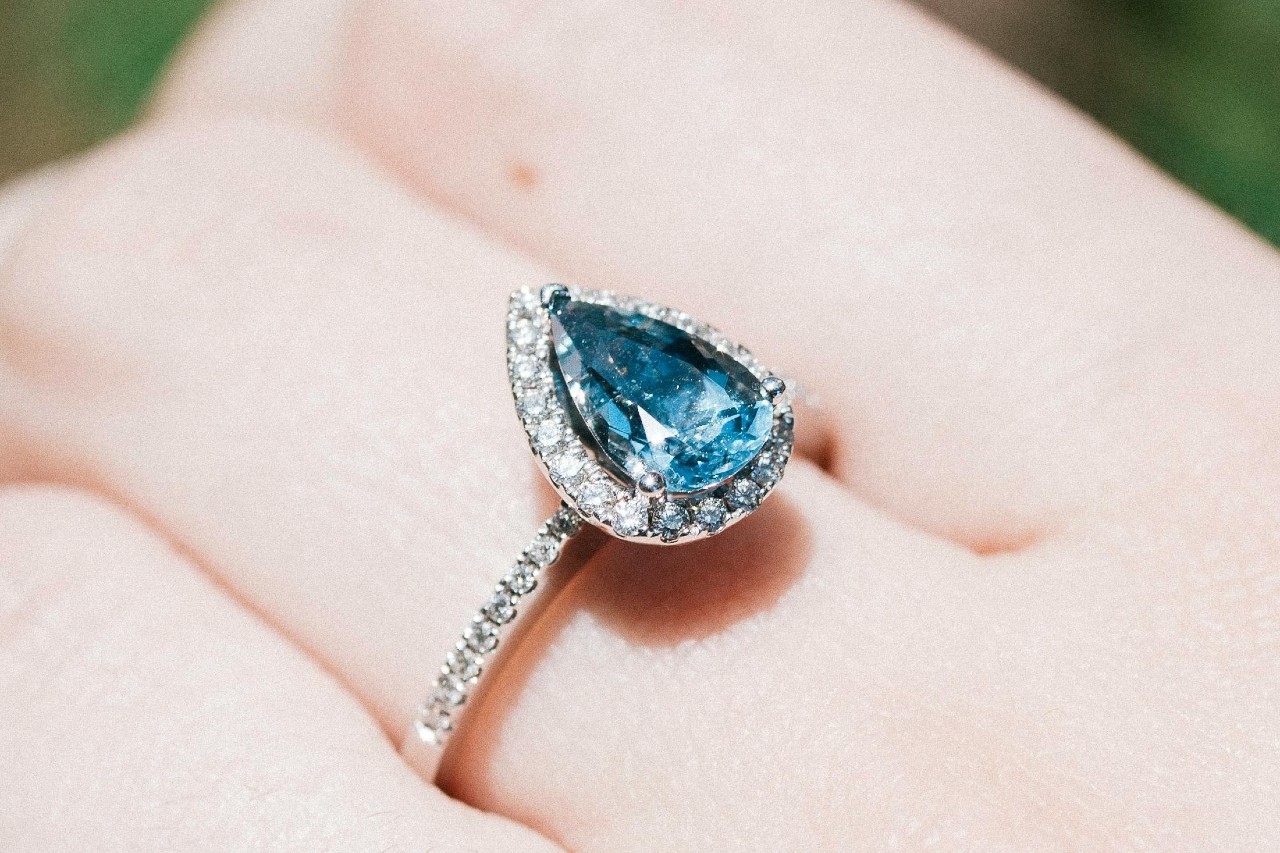 a woman’s hand wearing a pear shape aquamarine fashion ring