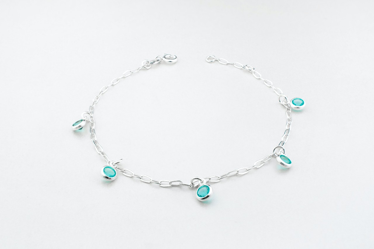 a white gold bracelet with station set blue gemstones