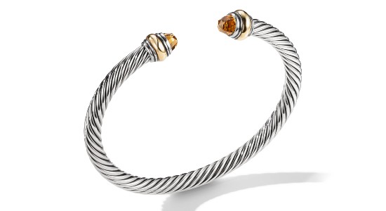 a silver cuff bracelet with two citrine gems