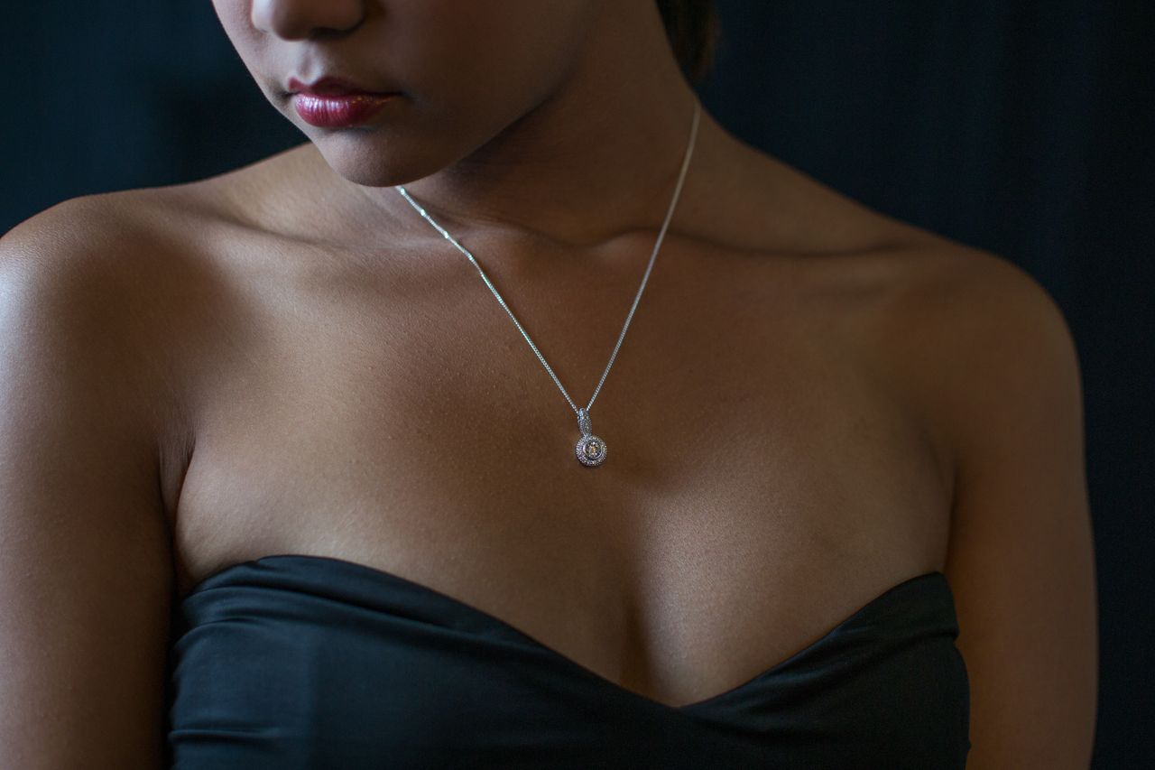 A woman wearing a diamond pendant necklace