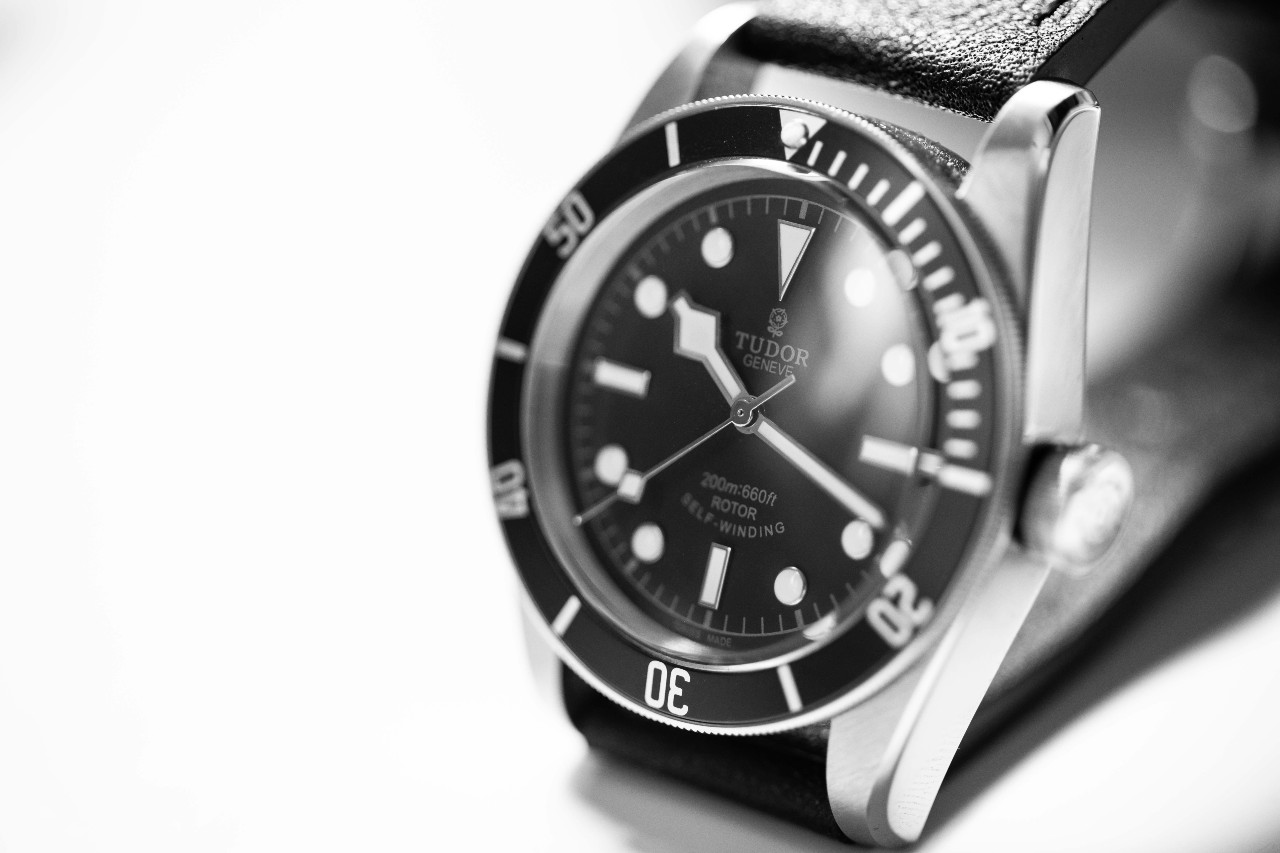 A black and white photo of a classic TUDOR watch