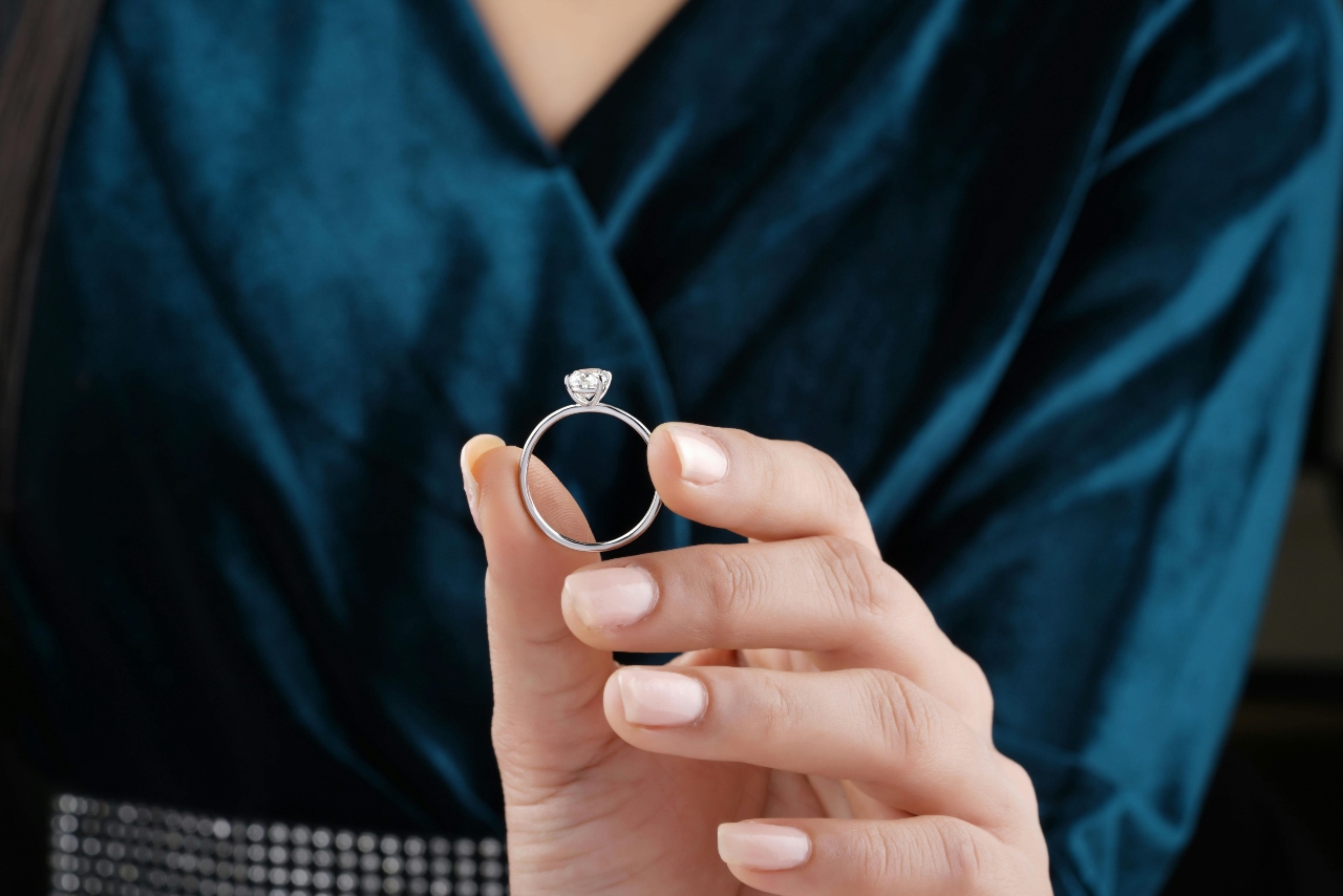 a lady’s hand holding an engagement ring