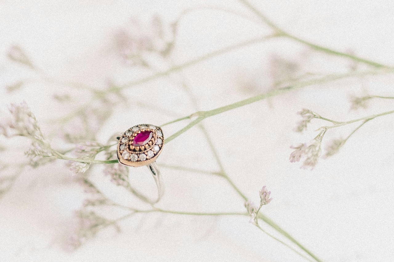 a mixed metal ring with a pink, marquise cut center stone