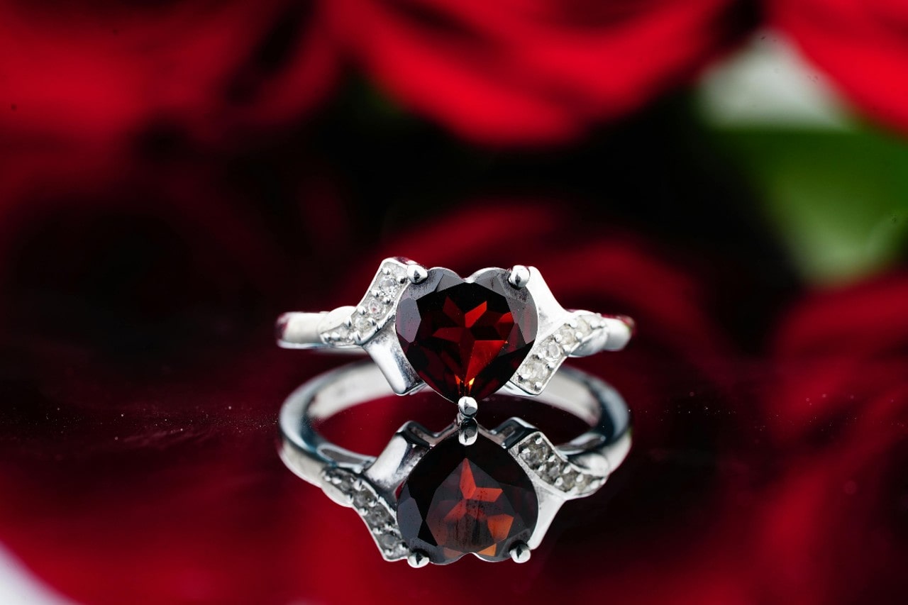 a white gold engagement ring with a heart shape ruby center stone 