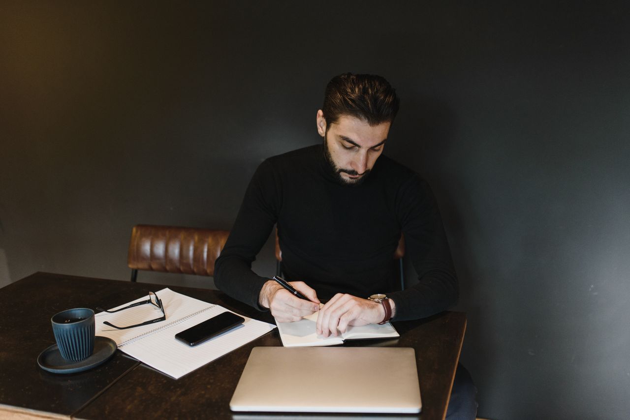 man writing with watch on wrist