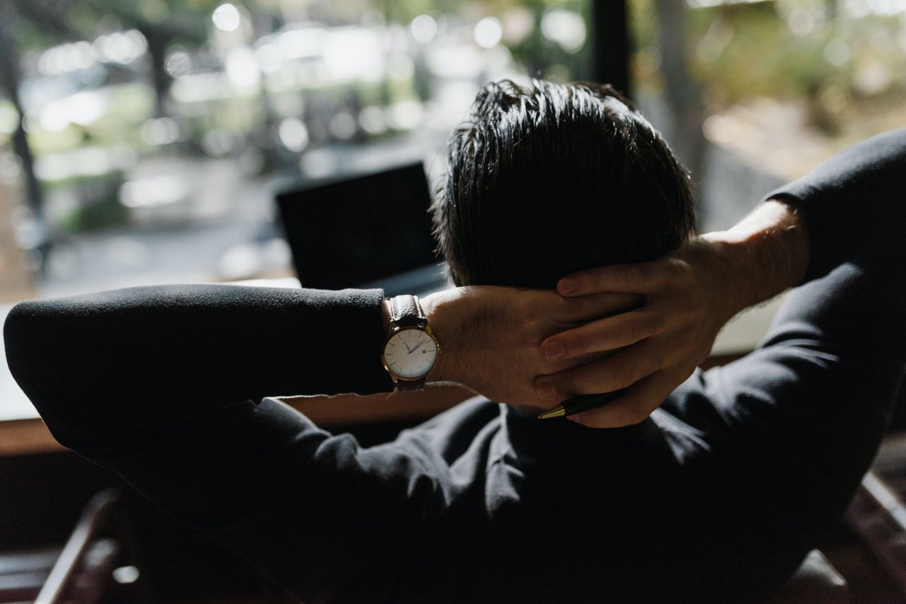 man with hands behind his head with watch on wrist